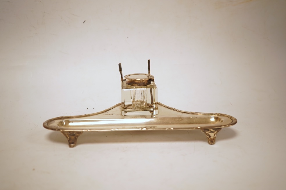 A George V silver inkstand, with single mounted glass well, pen rest and pen recess, with reeded ribbon border, William Hutton & Sons, Sheffield, 1913, 23.9cm, 5.2oz.